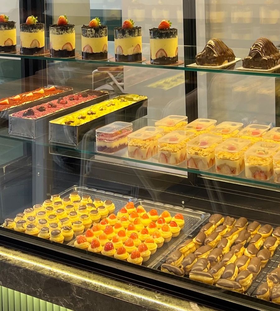 Molla Patisserie vitrininde çikolatalı ekler, mini tartlar ve kutuda tatlılar